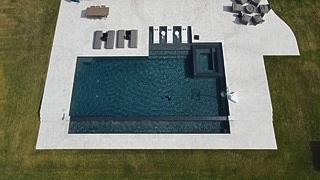 geometric-pool-2 Aerial view of a geometric swimming pool with a surrounding deck and lounge chairs.